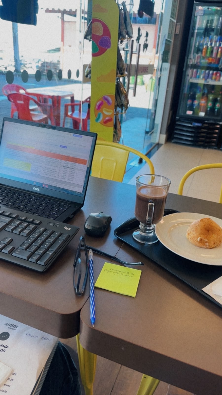 Mesa da conveniência com notebook, café quente e pão de queijo